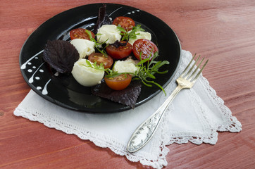 Italian caprese salad with fresh basil leaves