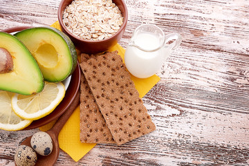 Fresh avocado on cutting board over wooden background