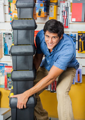 Man Carrying Stacked Toolboxes In Hardware Store