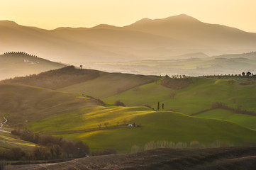 Spring wonderful landscape of Tuscany, green fields, sunrise and