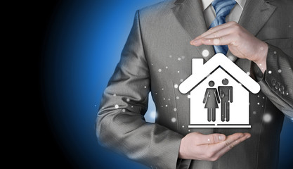 businessman protecting family in home with hands