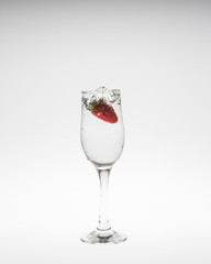 fresh strawberry dropped into water with splash on white backgro