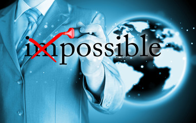 Businessman Hand turning the word Impossible into Possible with