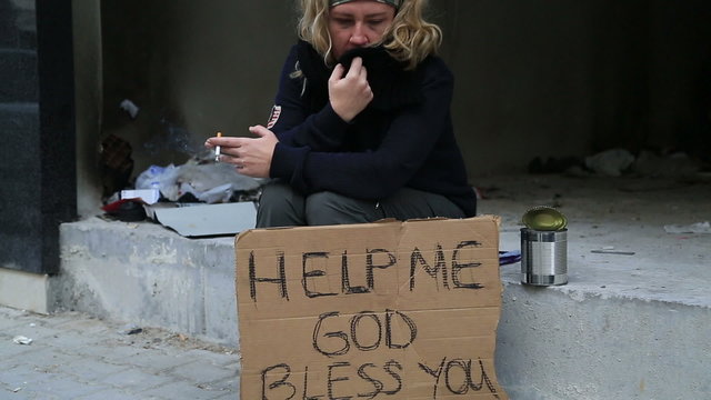 Homeless woman begging and smoking cigarette