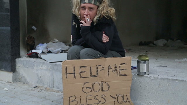 Homeless woman begging and smoking cigarette