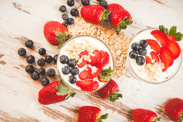 Strawberries, blueberries and breakfast cereal in yogurt on a wo