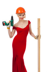 Beautiful blonde in a red dress with an electric drill