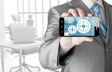 businessman show gear on smartphone to success concept