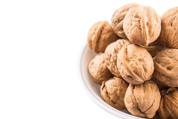 Walnuts in a white bowl over white background