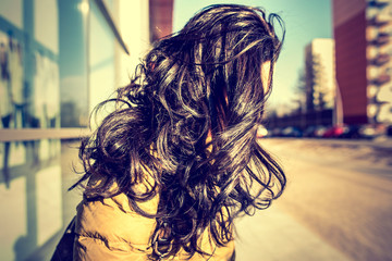 Brunette girl with long curly hair outdoor
