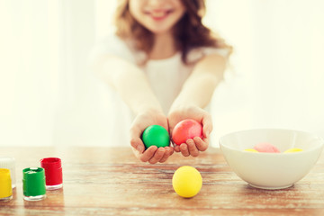 Obraz na płótnie Canvas close up of girl holding colored eggs