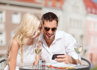 couple looking at smartphone in cafe
