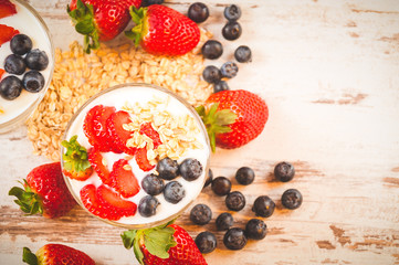 Strawberries, blueberries and breakfast cereal in yogurt on a wo