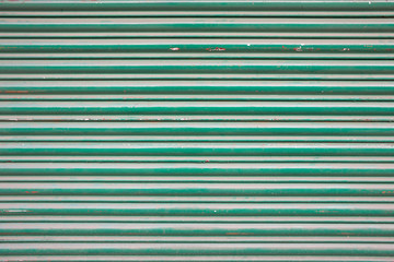 Fototapeta premium Large green metallic tin stripy fence background with scratches