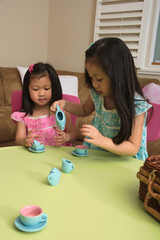 Asian toddlers playing with tea set