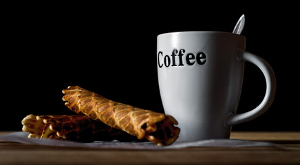 Wafer rolls and cup of coffee.