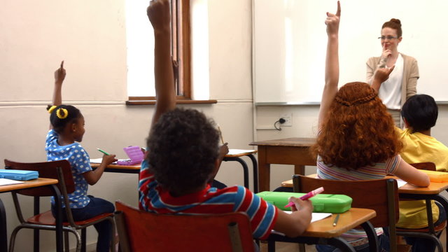 School children raising hands in class
