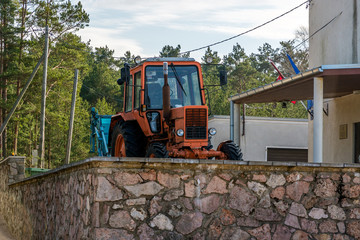 Orange tractor on a stone wall