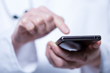 Close-up of hands of doctor using phone