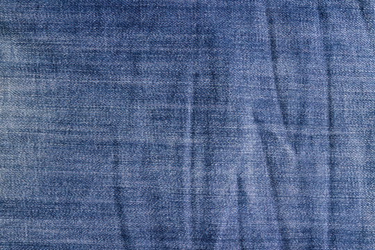 Crumpled vintage jeans texture, blue jeans background.