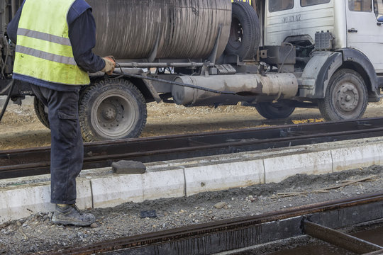 Road worker spraying manually bitumen emulsion