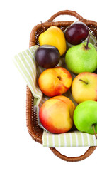 Assortment of juicy fruits in wicker basket, isolated on white