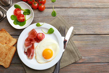Bacon and eggs on rustic wooden planks background