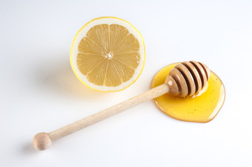 half of lemon and honey with wooden dipper