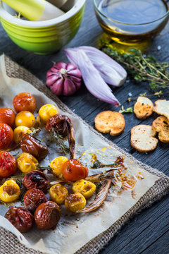 Freshly roasted vegetables with herbs on wooden table