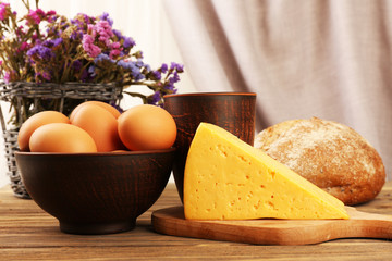 Tasty dairy products with bread and dry flowers