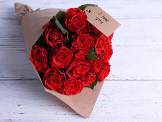 Bouquet of red roses with tag wrapped in paper