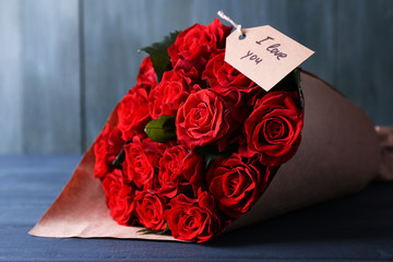 Bouquet of red roses with tag wrapped in paper