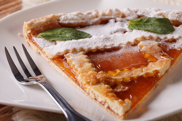 Piece of Italian tart with apricot jam on the plate