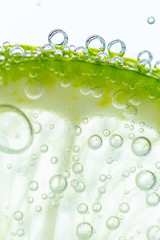 Slice of lime in water with bubbles - 79519985