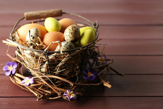 Bird eggs in wicker basket with decorative flowers