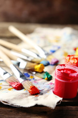 Brushes with colorful paints on dirty cloth