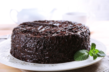 Tasty chocolate cake with cup of tea on table close up