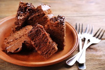 Slices of tasty chocolate cake on plate on table close up