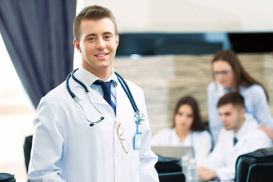 Attractive male doctor with team in conference room