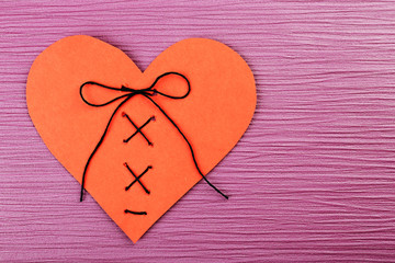 Stitched heart on colour background