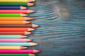 Group of color pencils on rustic wooden background