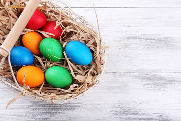 Easter eggs in basket on vintage wooden planks background