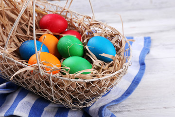Fototapeta na wymiar Easter eggs in basket on vintage wooden planks background