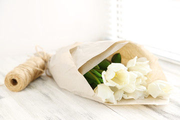 White beautiful tulips on wooden windowsill