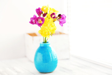 Colorful beautiful freesias on wooden windowsill