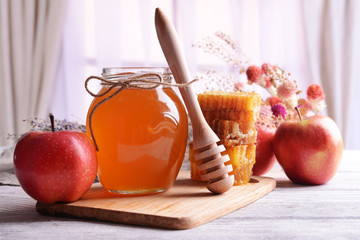 Delicious honey with apple on table on light background