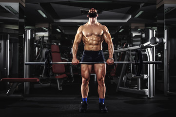 Fototapeta na wymiar Muscular Man Lifting Barbells