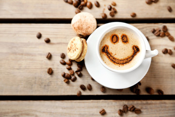 Cup of coffee  and macaroons on old wooden table