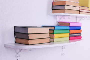 Books on shelves on white wall background