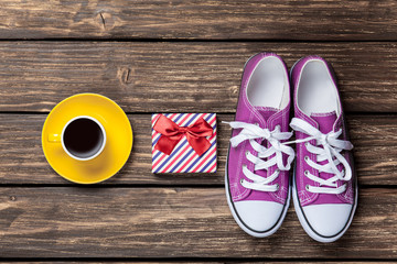 Gumshoes and gift box with coffee cup